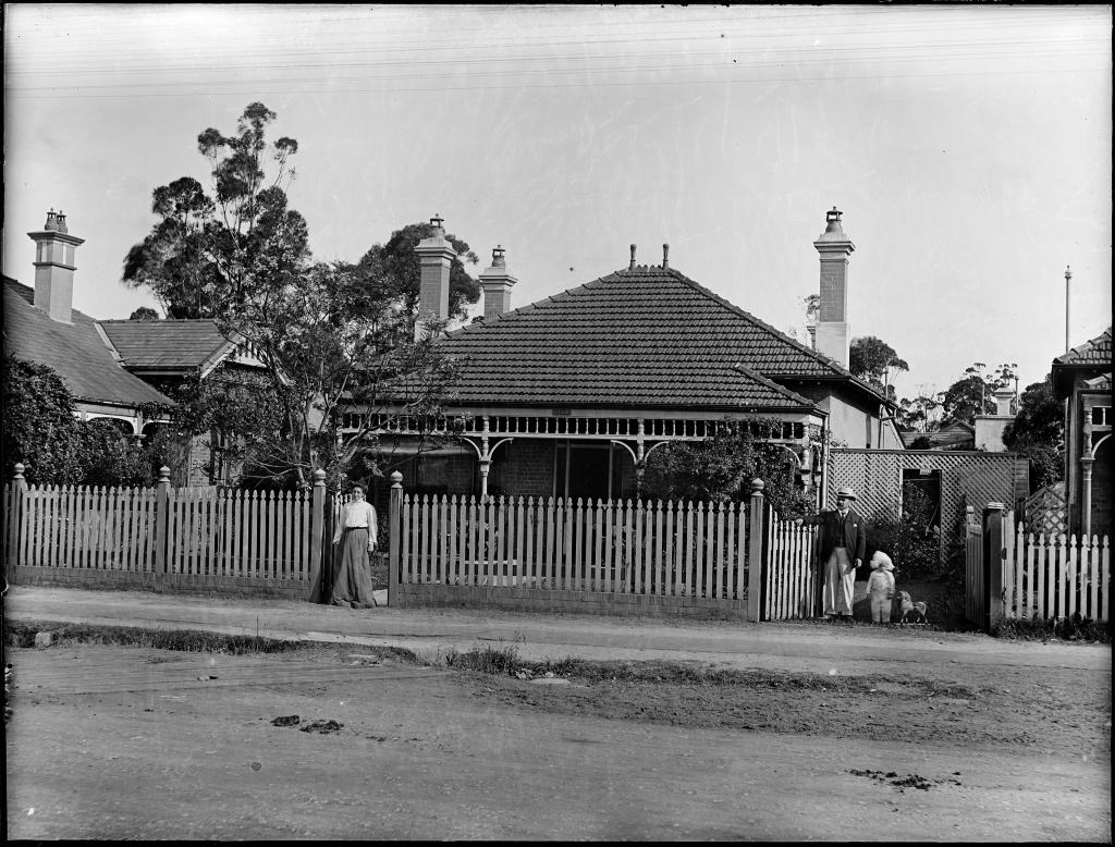 A suburban brick house on an unpaved street