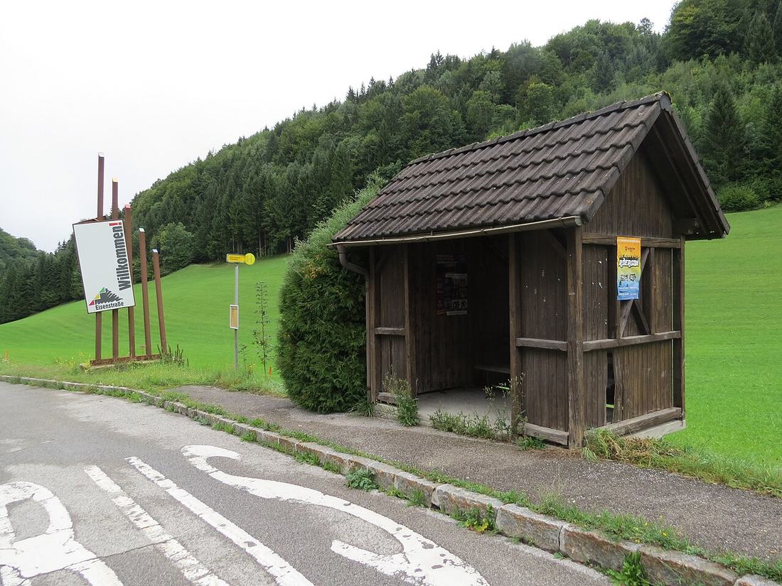 A bus stop shelter by a road